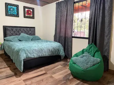 a bedroom with a bed and a window at Finca campestre mi retoño in Medellín