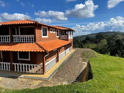 a house with an orange roof on a hill at Finca campestre mi retoño in Medellín