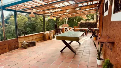 a ping pong table on a patio with a pergola at Finca campestre mi retoño in Medellín