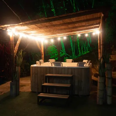 a table with chairs under a pergola with lights at EcoHotel Casa Maria Parda in Cocorná