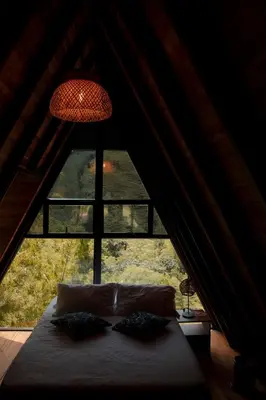 a bed in a room with a large window at EcoHotel Casa Maria Parda in Cocorná