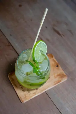 a drink with a lime on a wooden plate at EcoHotel Casa Maria Parda in Cocorná
