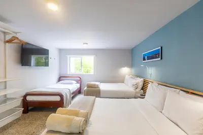 a small room with two beds and a couch at Cabaña familiar BANIA con vista del embalse al lado de la piedra in Guatapé