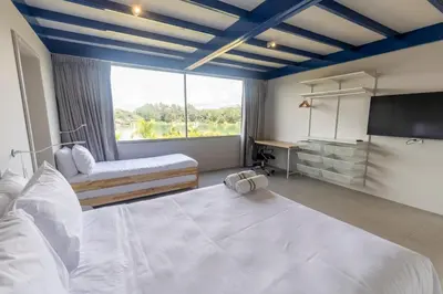 a bedroom with two beds and a large window at Cabaña familiar BANIA con vista del embalse al lado de la piedra in Guatapé