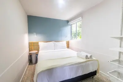a small bedroom with a bed and a window at Cabaña familiar BANIA con vista del embalse al lado de la piedra in Guatapé