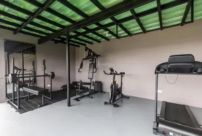a gym with treadmills and elliptical machines at Cabaña familiar BANIA con vista del embalse al lado de la piedra in Guatapé