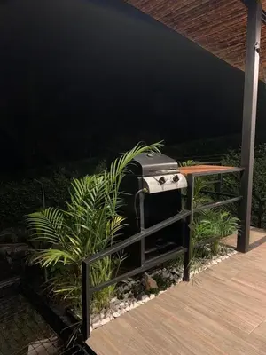 a grill sitting next to a table and some plants at Verdes Hábitat Glamping in Palestina