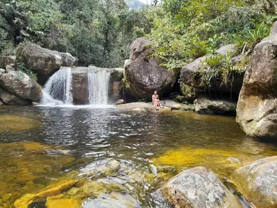 a person standing in the water in front of a waterfall at Casa Horizontes in San Carlos