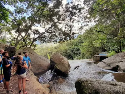 a group of people standing on rocks in a river at Casa Horizontes in San Carlos