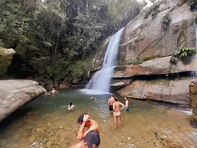 a group of people in the water in front of a waterfall at Casa Horizontes in San Carlos