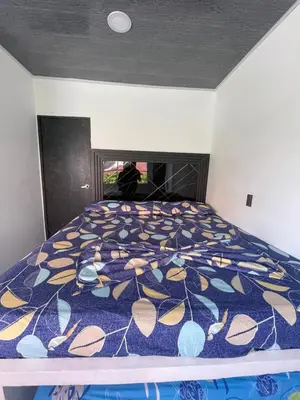 a bedroom with a bed with a blue and yellow comforter at Apartamento vacacional Galeon Doradal in Doradal