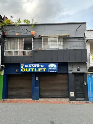 a building with two garage doors in front of it at Aparta estudio amoblado 4 Medellín, San Joaquín in Medellín