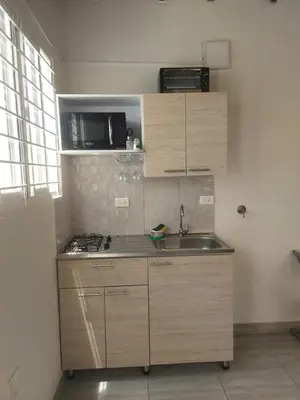 a small kitchen with wooden cabinets and a sink at Aparta estudio amoblado 4 Medellín, San Joaquín in Medellín