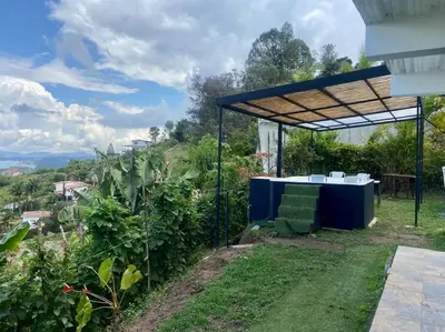 a table and chairs under a canopy in a garden at BERAKHAH SPA & ROOMS in Guatapé