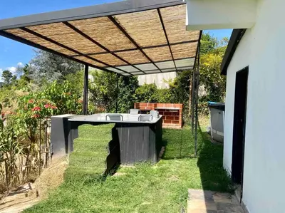 a patio with a table in the grass at BERAKHAH SPA & ROOMS in Guatapé