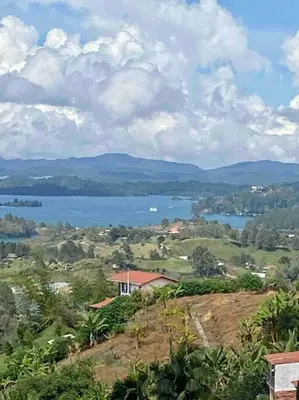 a view of a lake and a house on a hill at BERAKHAH SPA & ROOMS in Guatapé