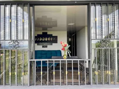 a vase of flowers sitting on a table in front of a window at BERAKHAH SPA & ROOMS in Guatapé
