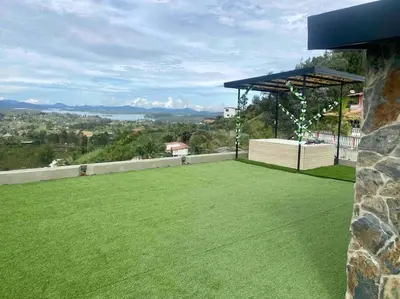 a large yard with green grass and a pavilion at BERAKHAH SPA & ROOMS in Guatapé