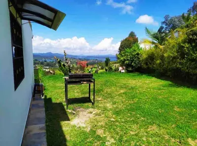 a view from the porch of a house with a green yard at BERAKHAH SPA & ROOMS in Guatapé