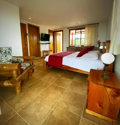 a bedroom with a bed and a couch and a television at Casa Chute in Chinchiná