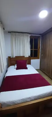 a bedroom with a large bed with a red pillow at Casa Chute in Chinchiná