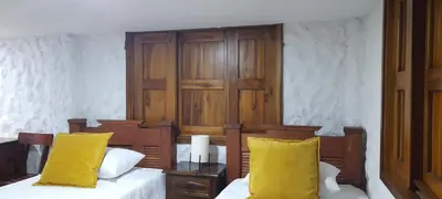 a bedroom with two beds with yellow pillows at Casa Chute in Chinchiná