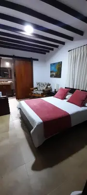 a large bedroom with a large bed with red pillows at Casa Chute in Chinchiná