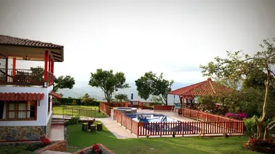 a backyard with a pool and a house at Casa Chute in Chinchiná