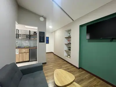 a living room with a couch and a flat screen tv at Apartamento en Medellín sector del Poblado A101 By Roots Rentals in Medellín