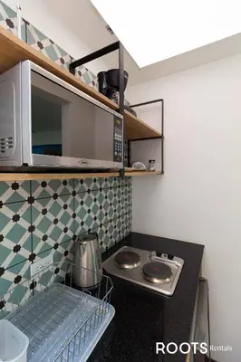 a kitchen with a stove and a microwave at Apartamento en Medellín sector del Poblado A101 By Roots Rentals in Medellín