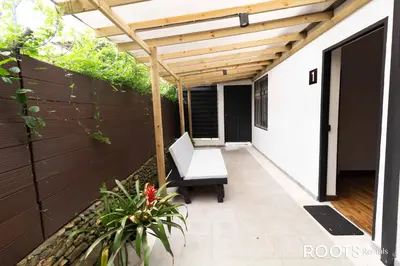 a patio with a wooden pergola and a bench at Económico alojamiento en Medellín por días - A102 By Roots Rentals in Medellín