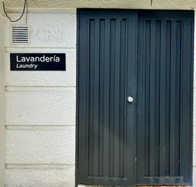 a door on the side of a building with a sign at Económico alojamiento en Medellín por días - A102 By Roots Rentals in Medellín
