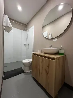 a bathroom with a sink and a toilet and a mirror at Económico alojamiento en Medellín por días - A102 By Roots Rentals in Medellín