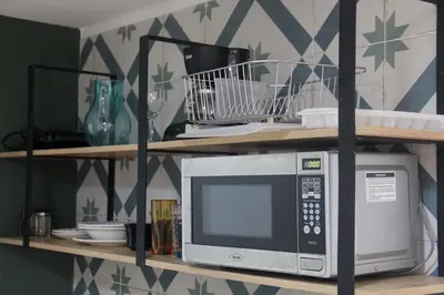 a microwave oven sitting on a shelf in a kitchen at Económico alojamiento en Medellín por días - A102 By Roots Rentals in Medellín