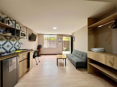 a kitchen and living room with a couch and a table at Económico alojamiento en Medellín por días - A102 By Roots Rentals in Medellín