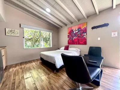 a bedroom with a bed and two chairs and a window at Alojamiento que permite mascota en Medellín A103 By Roots Rentals in Medellín