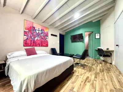a bedroom with a bed and a painting on the wall at Alojamiento que permite mascota en Medellín A103 By Roots Rentals in Medellín