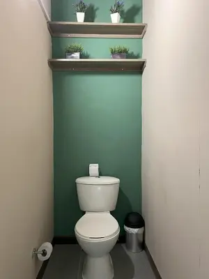 a bathroom with a toilet with plants on a shelf at Hospedaje cerca a centro comercial de Santafé A104 By Roots Rentals in Medellín