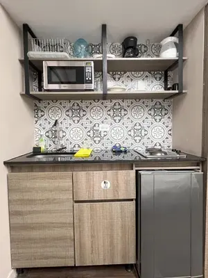 a kitchen with a sink and a microwave at Hospedaje cerca a centro comercial de Santafé A104 By Roots Rentals in Medellín