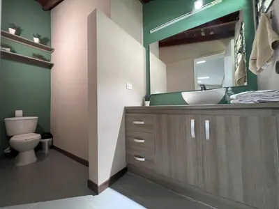a bathroom with a sink and a toilet and a mirror at Hospedaje cerca a centro comercial de Santafé A104 By Roots Rentals in Medellín