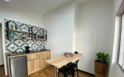 a kitchen with a table and chairs in a room at Apartamento cerca al centro comercial Santafé A105 By Roots Rentals in Medellín