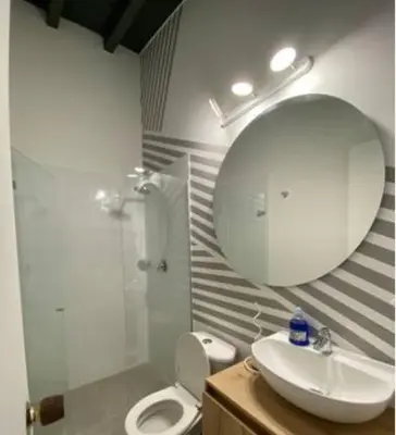 a bathroom with a sink and a mirror and a toilet at Apartamento cerca al centro comercial Santafé A105 By Roots Rentals in Medellín