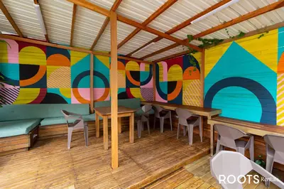 a room with tables and chairs and a colorful wall at Apartamento cerca al centro comercial Santafé A105 By Roots Rentals in Medellín