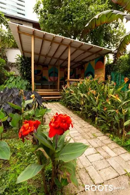 a garden with red flowers in front of a building at Apartamento cerca al centro comercial Santafé A105 By Roots Rentals in Medellín