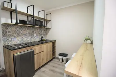 a kitchen with wooden cabinets and a wooden table at Cómodo aparta suite en zona Poblado Medellín M101 By Roots Rentals in Medellín