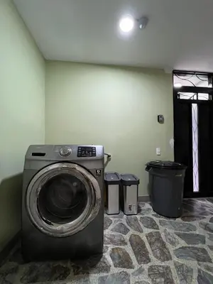 a washing machine in a room with two trash cans at Cómodo aparta suite en zona Poblado Medellín M101 By Roots Rentals in Medellín