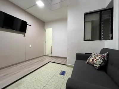 a living room with a couch and a flat screen tv at Cómodo aparta suite en zona Poblado Medellín M101 By Roots Rentals in Medellín