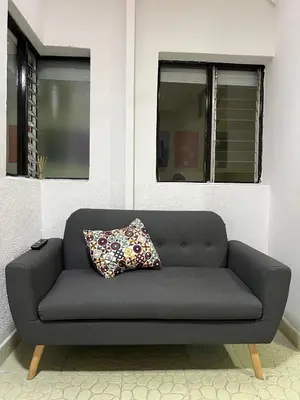 a couch in a room with two windows at Cómodo aparta suite en zona Poblado Medellín M101 By Roots Rentals in Medellín