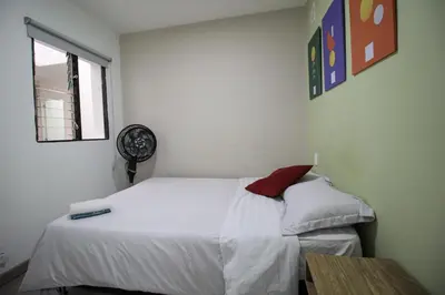 a bedroom with a white bed and a window at Cómodo aparta suite en zona Poblado Medellín M101 By Roots Rentals in Medellín