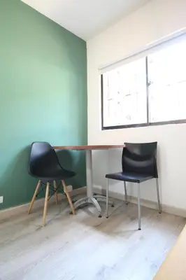 an office with two chairs and a desk and a window at Económica Suite en sector Manila el Poblado M102 By Roots Rentals in Medellín